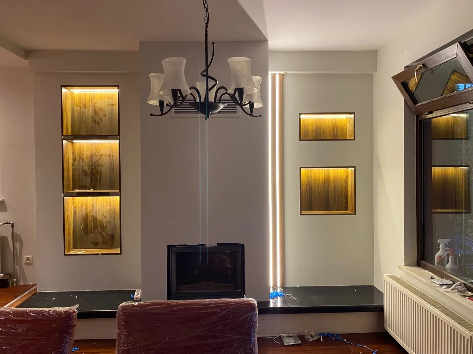 Aydınlatma yanarken şömine duvarı ve salon